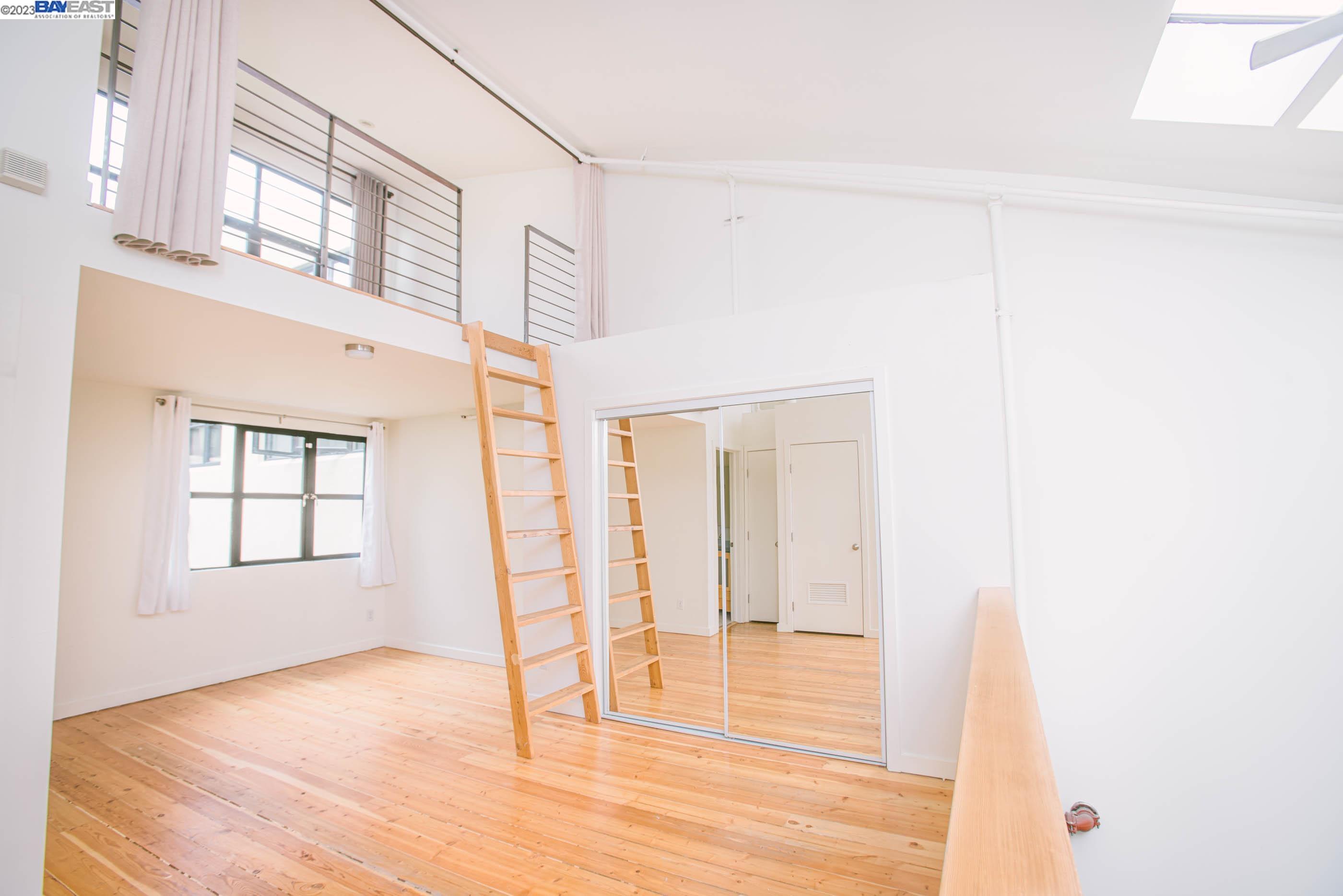 1695 15th Street, Unit 15 Oakland, CA 94607 - Photo 4 of 22 a view of an empty room with wooden floor and a window
