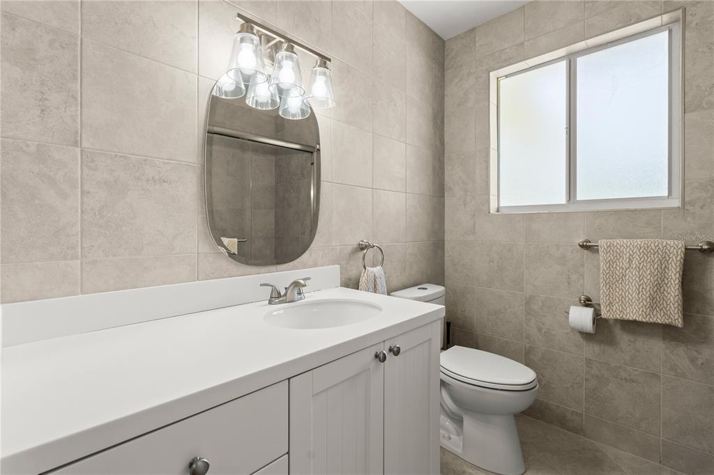 1020 Old Big Tree Road Daytona Beach, FL 32119 - Photo 18 of 37 a bathroom with a toilet a sink and mirror