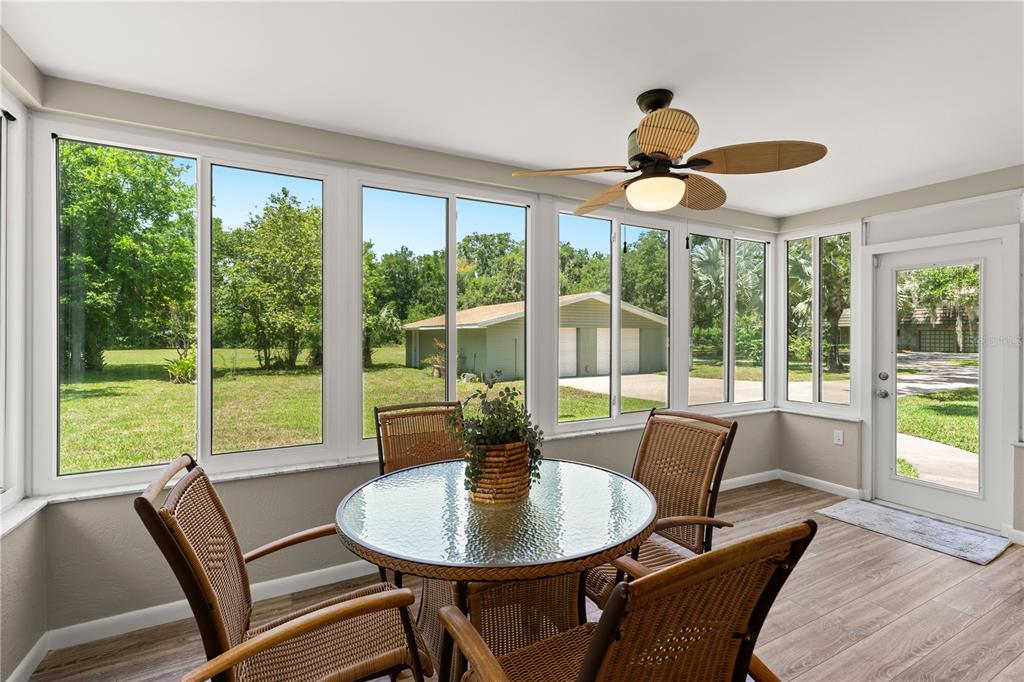 1020 Old Big Tree Road Daytona Beach, FL 32119 - Photo 22 of 37 a dining room with wooden floor a chandelier a glass table and chairs