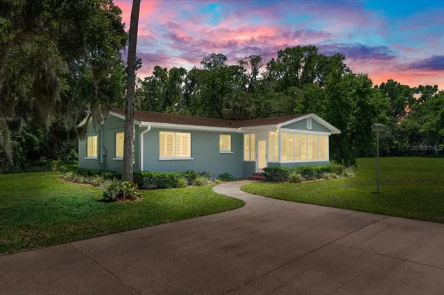a front view of a house with a yard and trees