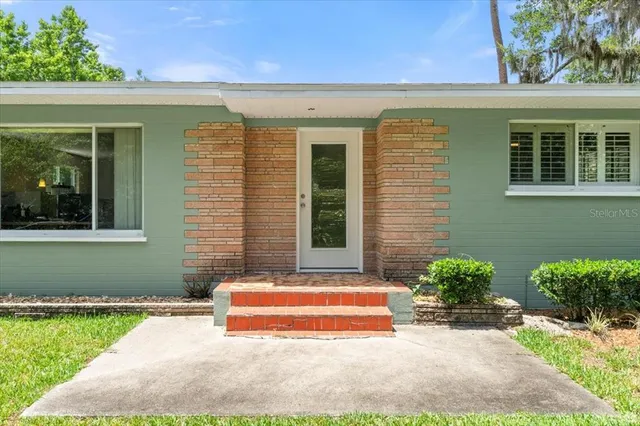 a view of a house with backyard and sitting area