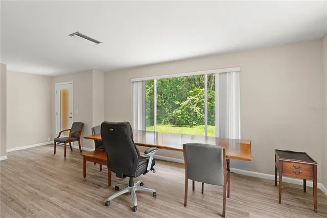 a view of a workspace with furniture and a window