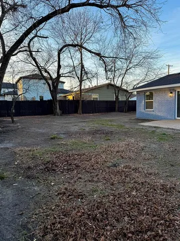 a backyard of a house with large trees and barbeque oven