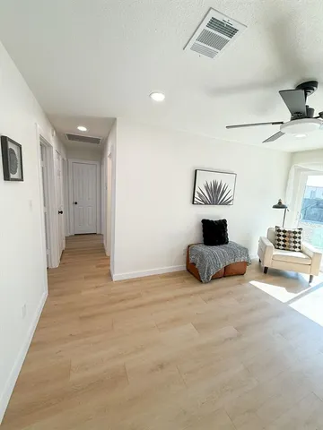 a room with a wooden floor and white appliances