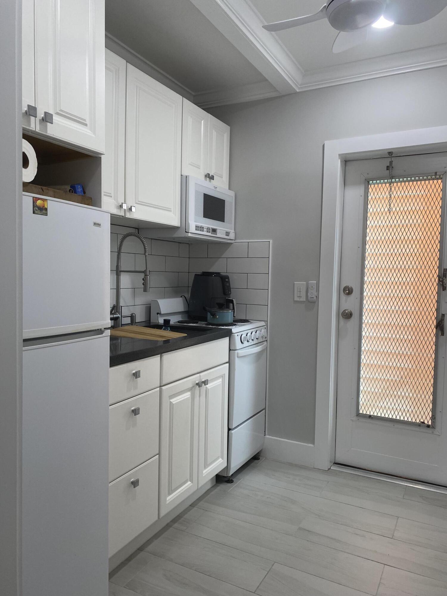 31 South Golfview Road, Unit 5 Lake Worth Beach, FL 33460 - Photo 2 of 11 a kitchen with stainless steel appliances a refrigerator sink and cabinets