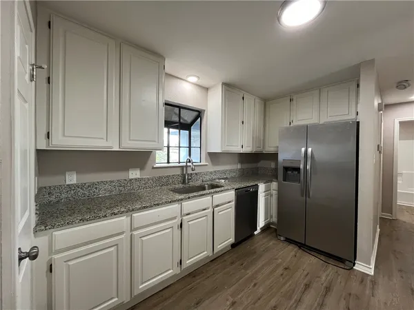a kitchen with stainless steel appliances granite countertop a stove a sink and a refrigerator
