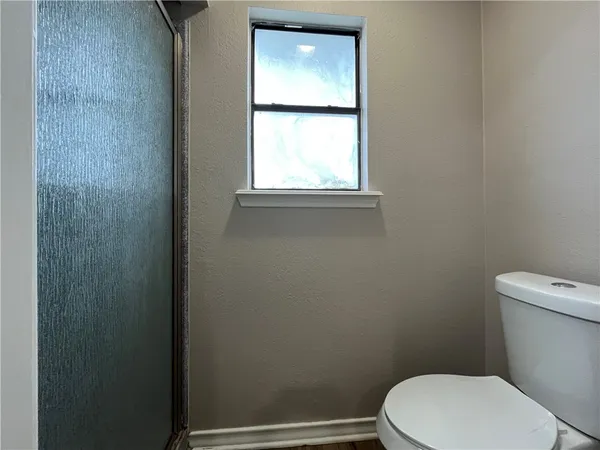 a white toilet sitting next to a window