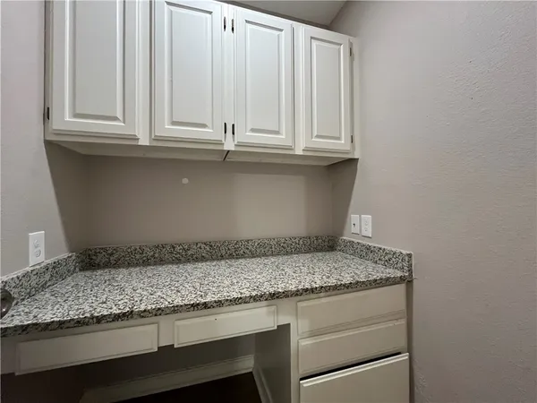 a kitchen with granite countertop white cabinets and a sink