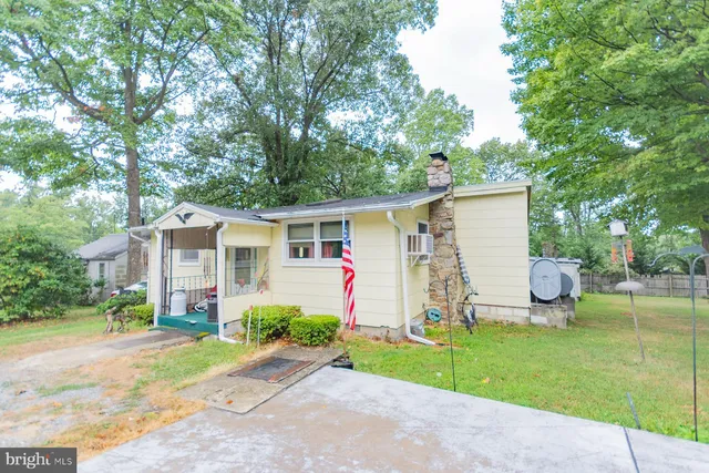 a view of a house with backyard and a tree