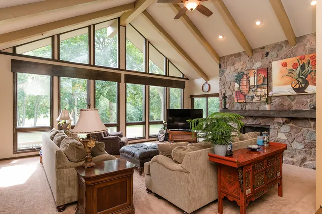 a living room with fireplace furniture and a large window