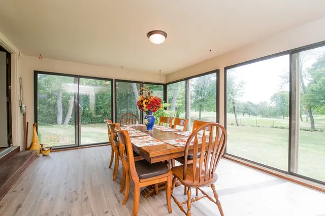 a dining room with furniture water view and a floor to ceiling window