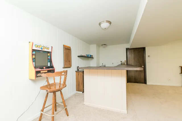 a kitchen with a refrigerator and table chairs