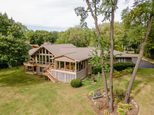 aerial view of a house with a big yard and large trees