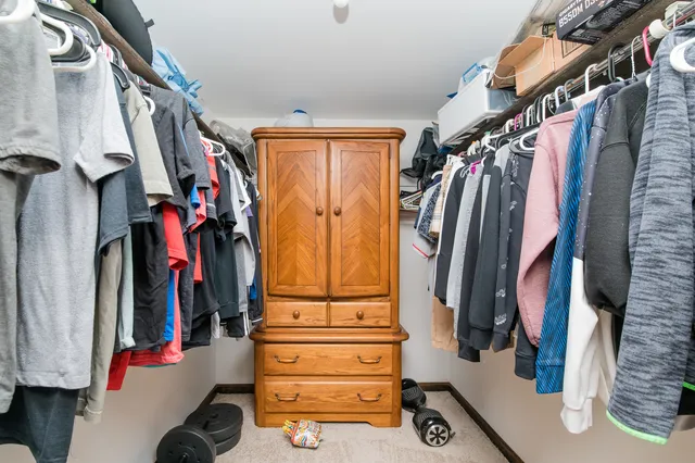 a view of walk in closet with clothes