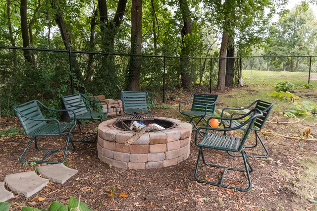 a view of a chairs and table in the backyard