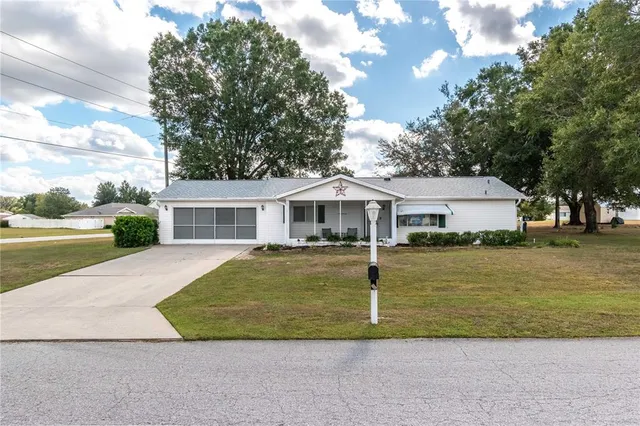 a front view of a house with a yard and trees