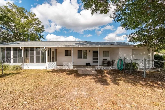 a kitchen with stainless steel appliances granite countertop a refrigerator a sink dishwasher a stove and a dining table with wooden floor