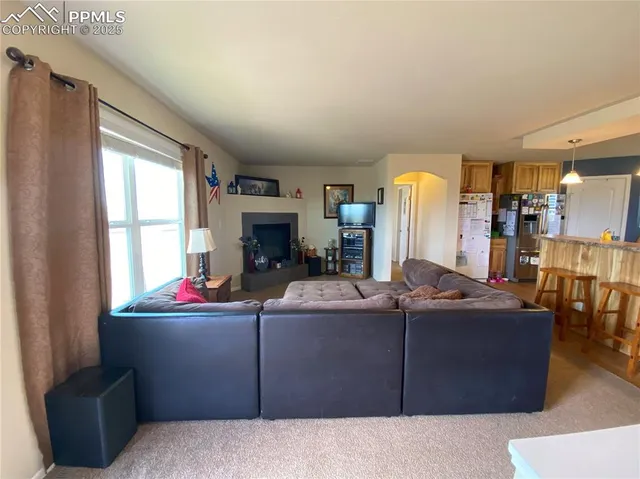 a living room with furniture a window and a flat screen tv