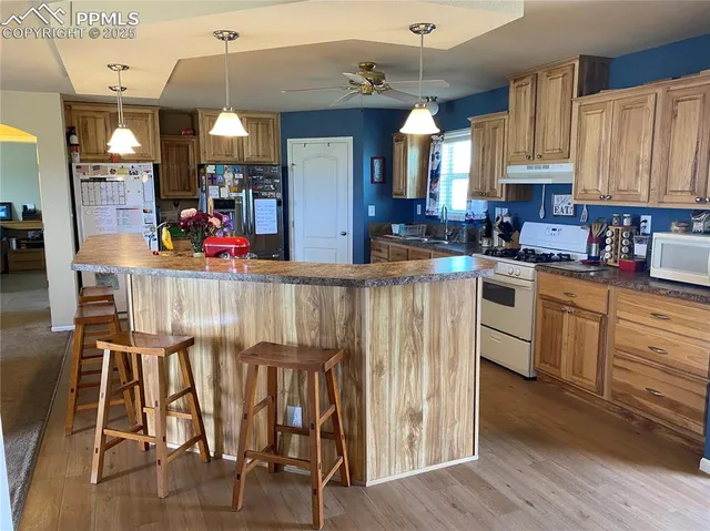 a kitchen with granite countertop wooden floors and white cabinets