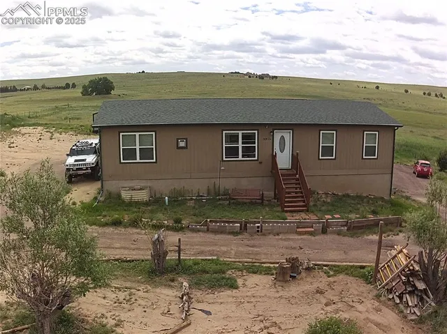 a view of a house with a yard and potted plants