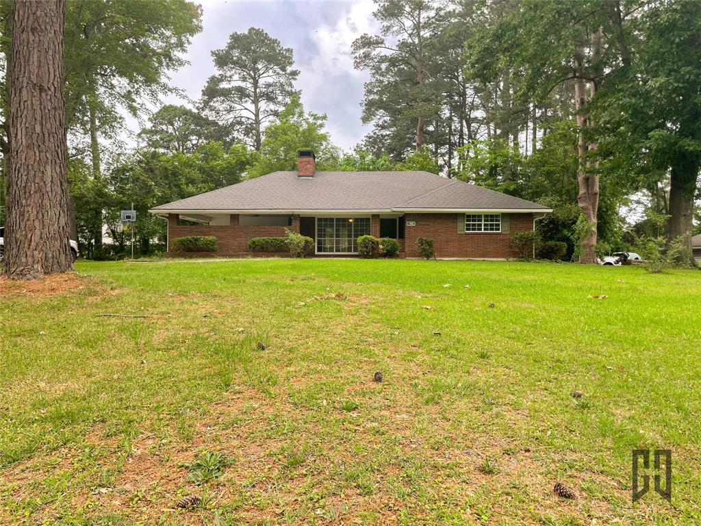 702 Browning Drive Springhill, LA 71075 - Photo 1 of 1 a house that has a big yard with plants and trees