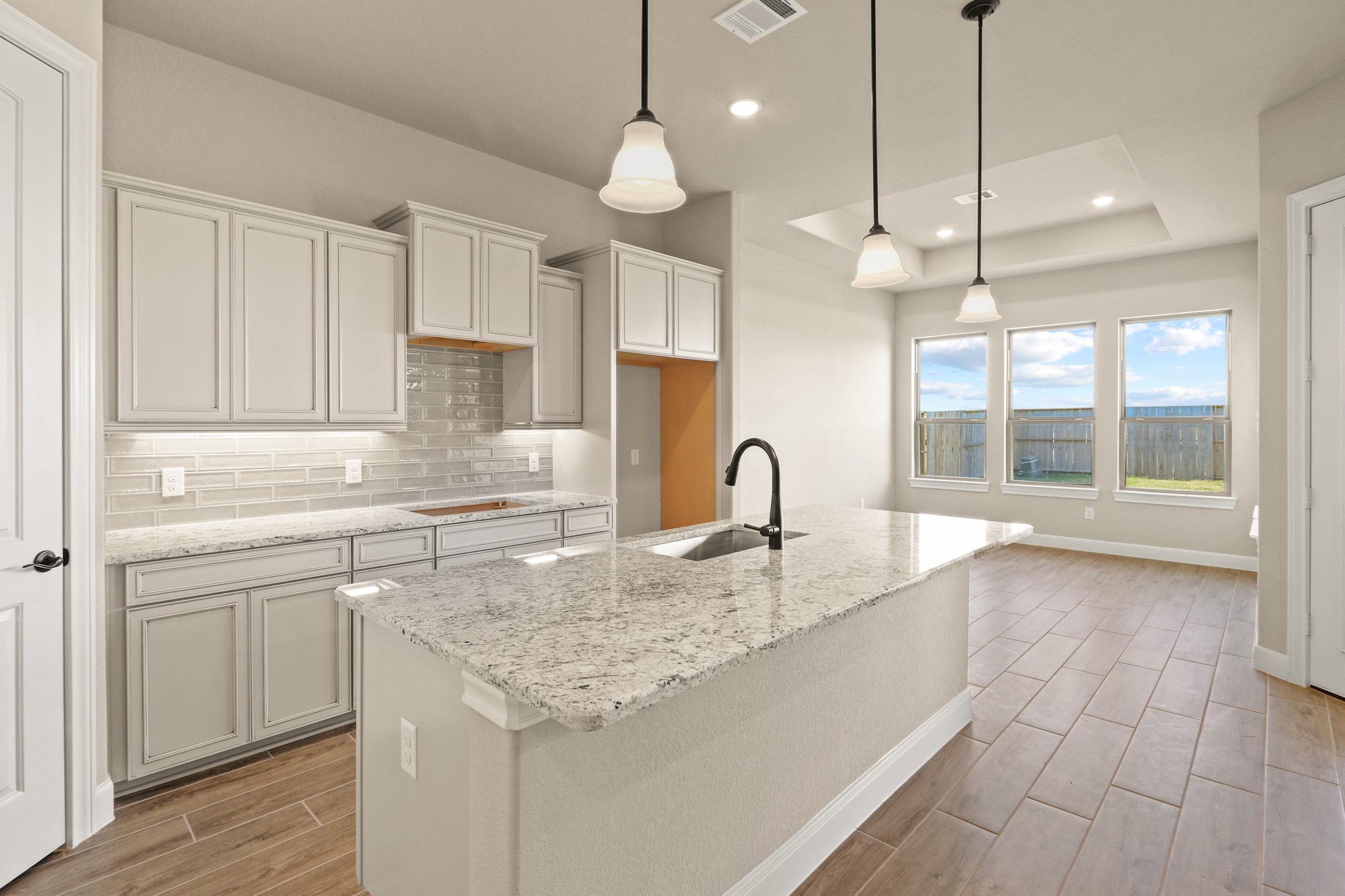 9510 Turnstone Drive Manvel, TX 77578 - Photo 8 of 19 Your chef-inspired kitchen is ready to impress! This beautifully designed space boasts gleaming granite countertops with coordinating tile backsplash. The rich cabinetry is perfectly complemented by under-cabinet lighting and recessed lighting, creating a bright and inviting ambiance. At the heart of it all, a sprawling island with breakfast bar seating offers the perfect spot for casual dining and entertaining.