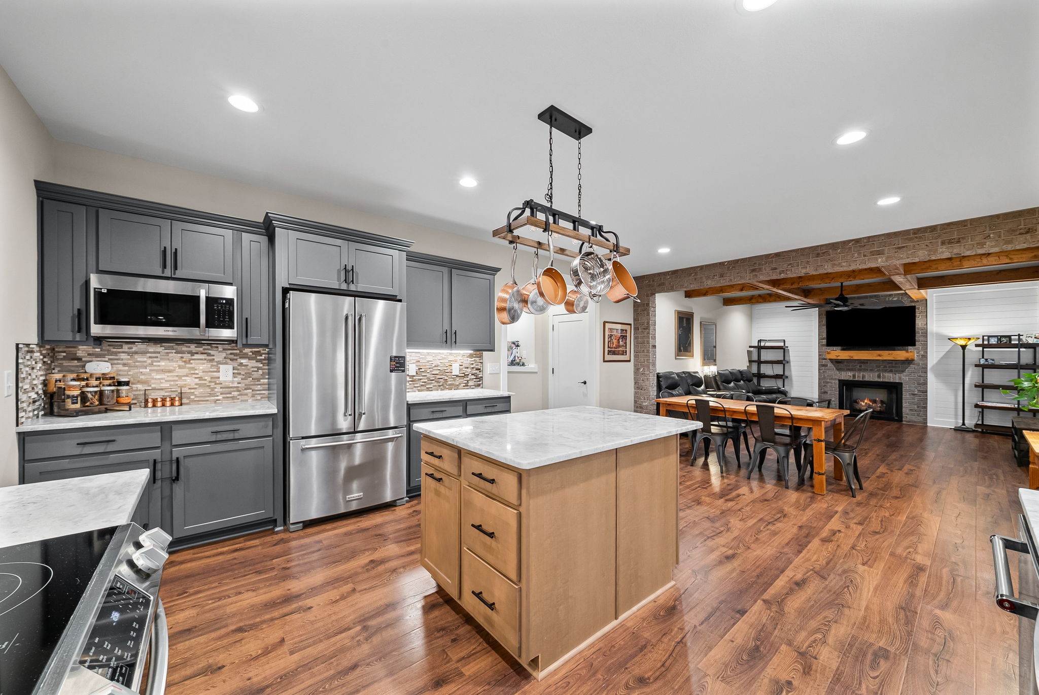 2854 Benton Ridge Road Palmyra, TN 37142 - Photo 18 of 64 a kitchen with stainless steel appliances granite countertop a refrigerator a stove top oven a sink dishwasher a dining table and chairs with wooden floor