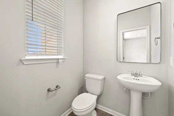 a bathroom with a sink a toilet and mirror