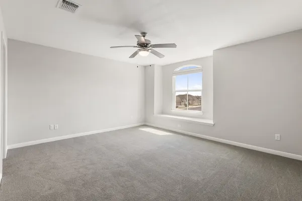 an empty room with a window and a ceiling fan