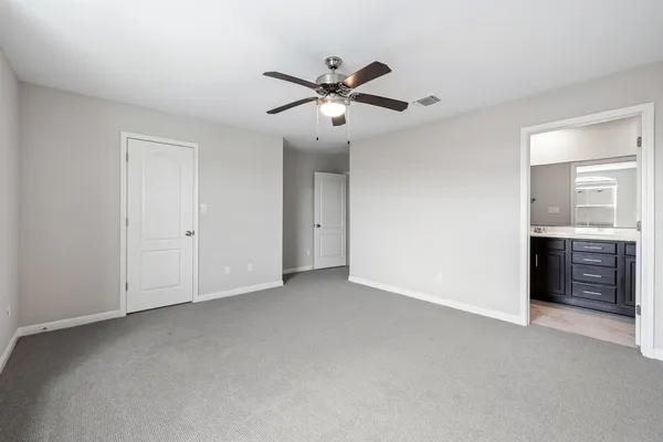 a view of an empty room with a ceiling fan