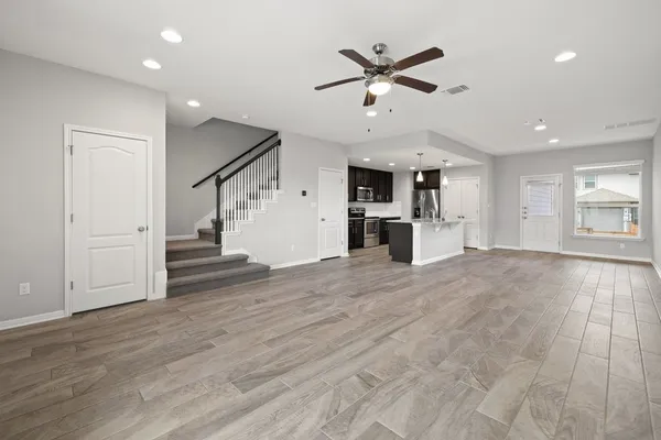 an empty room with kitchen and windows