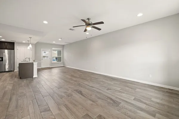 a view of an empty room with a kitchen
