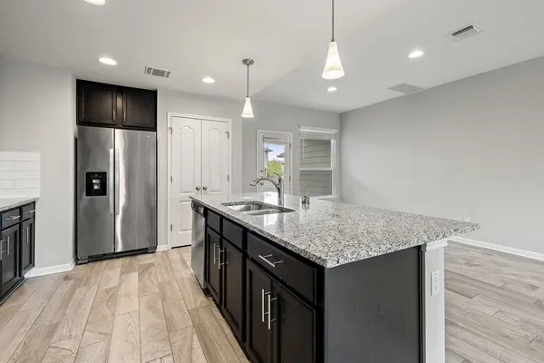 a kitchen with stainless steel appliances granite countertop a sink a refrigerator and a oven