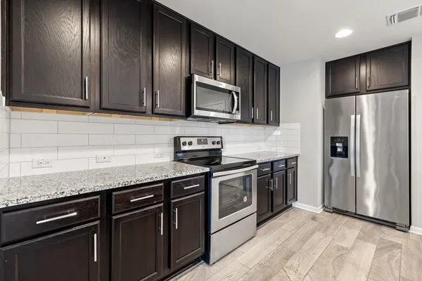 a kitchen with granite countertop stainless steel appliances and wooden cabinets