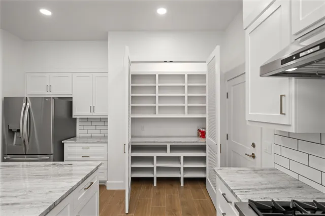 a kitchen with stainless steel appliances cabinets and a wooden floor