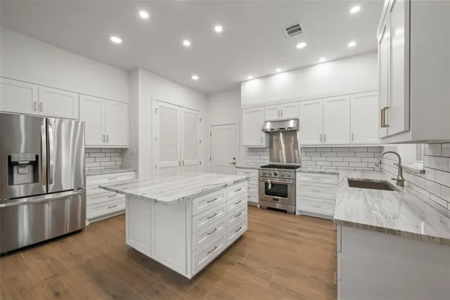 a kitchen with stainless steel appliances granite countertop a sink stove and refrigerator