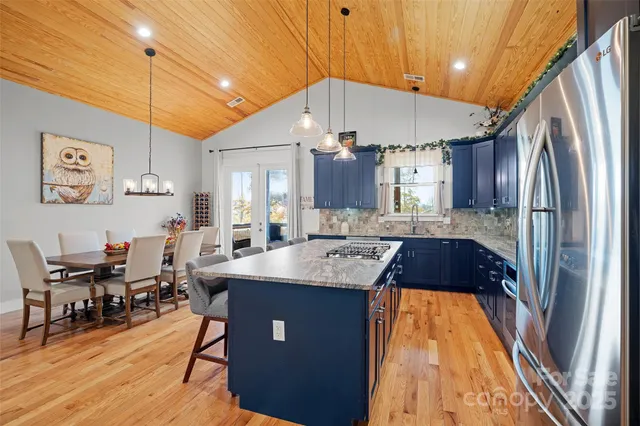 a kitchen with stainless steel appliances granite countertop a sink a stove and a refrigerator