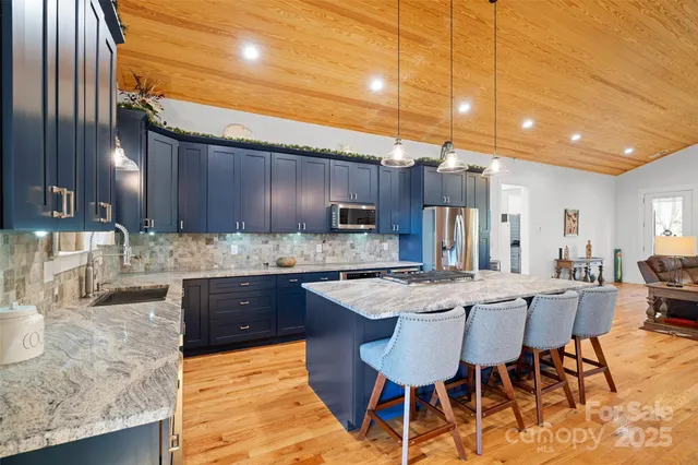 a large kitchen with granite countertop a sink and cabinets