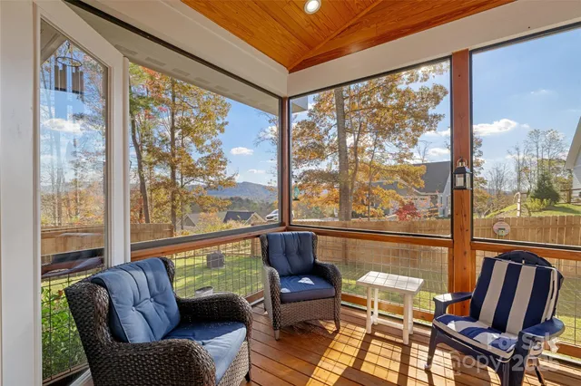 a living room with large windows and a table