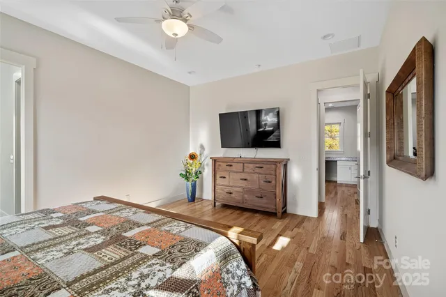 a bedroom with a bed and a flat tv screen on dresser
