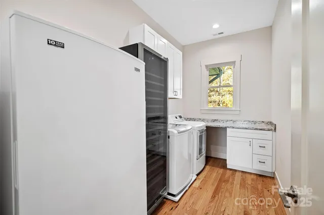 a kitchen with granite countertop a sink cabinets stainless steel appliances and a window
