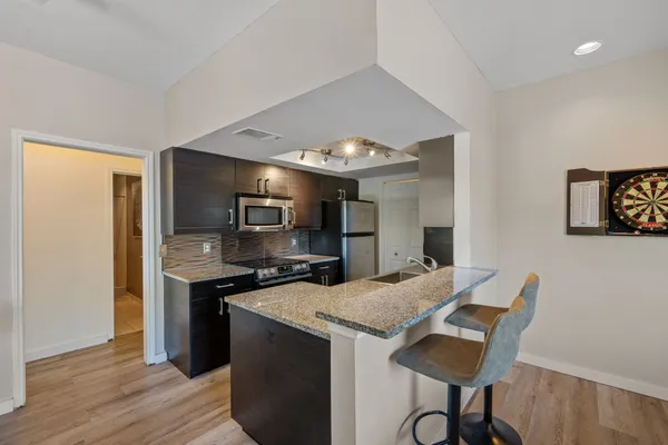a kitchen with granite countertop a stove and a wooden floor