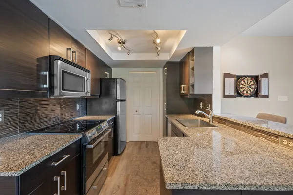 a kitchen with stainless steel appliances granite countertop a sink stove and refrigerator