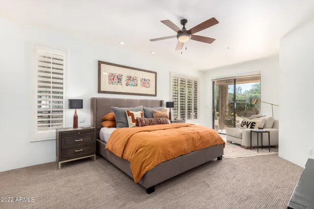 a bedroom with a bed and a large window