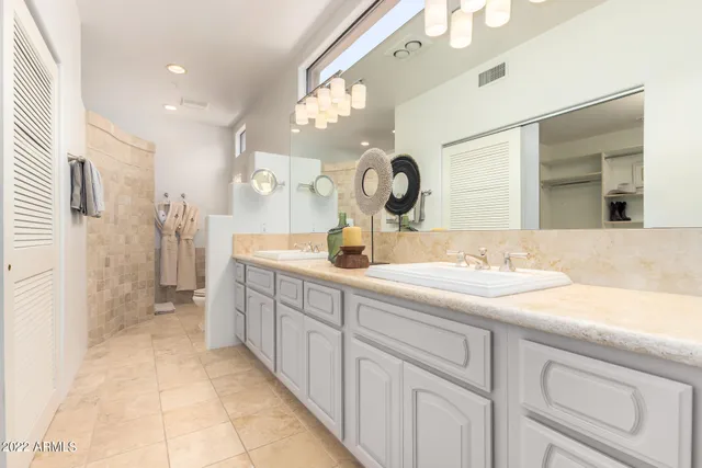 a spacious bathroom with a double vanity sink and a mirror
