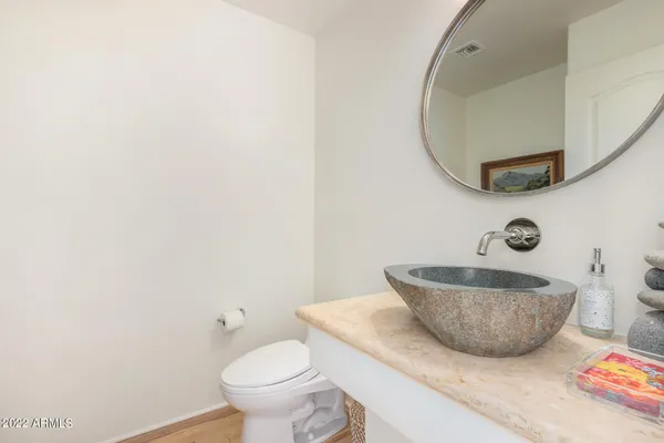 a bathroom with a granite countertop toilet and a mirror