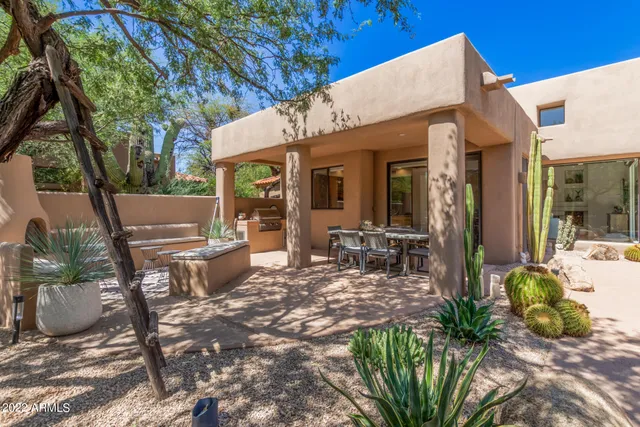 a view of a patio with table and chairs potted plants and large tree