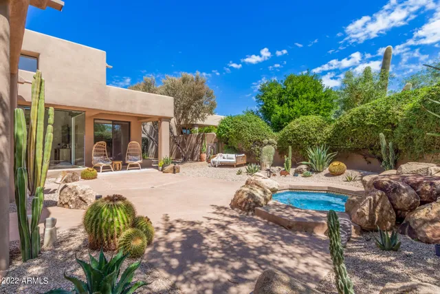 a view of a swimming pool with lawn chairs under an umbrella