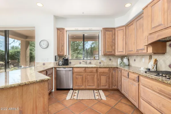 a large kitchen with granite countertop a sink and cabinets