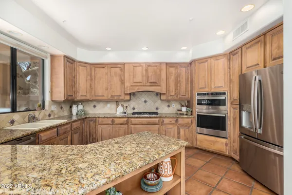 a kitchen with granite countertop a stove refrigerator and microwave